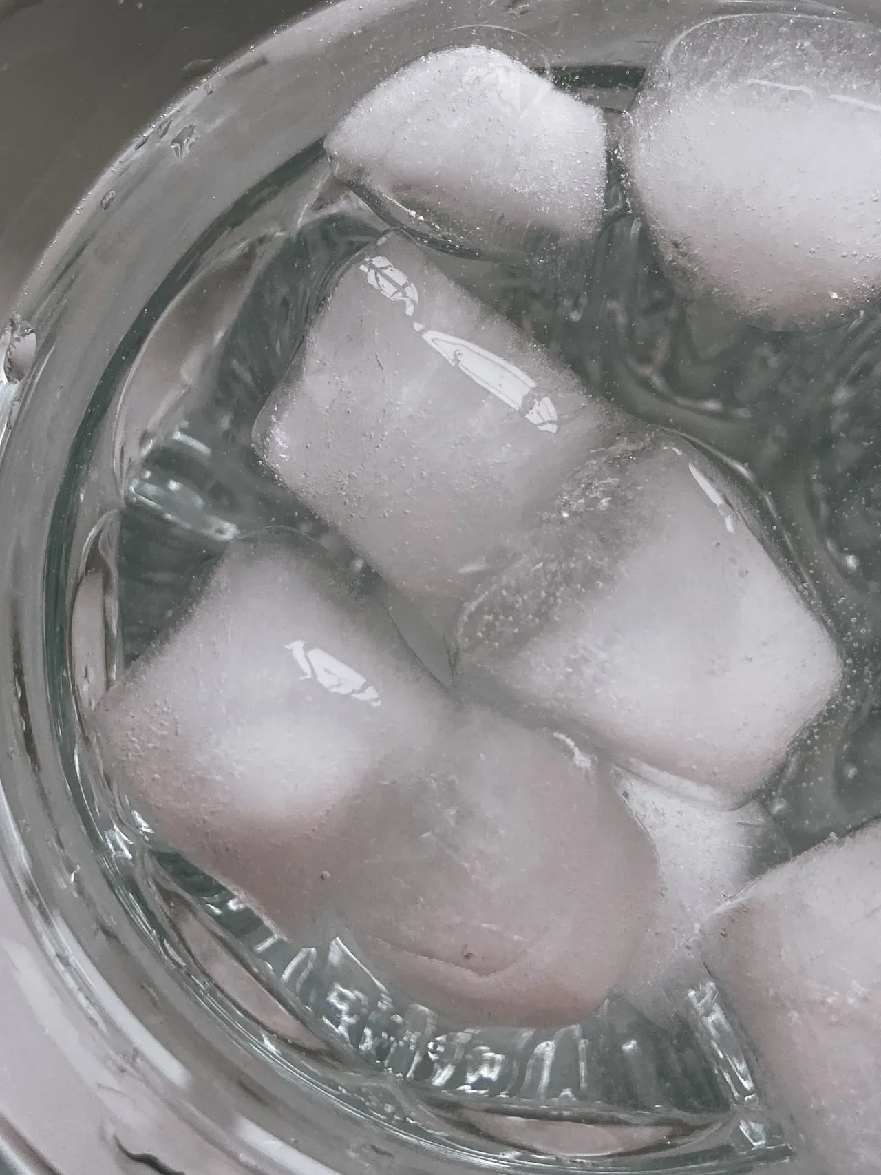 Cubitos de hielo sumergidos en agua fría para preparar un baño de hielo