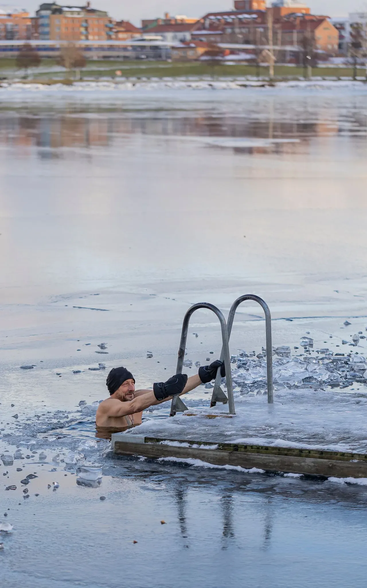 Dos personas sumergidas en un lago parcialmente helado durante el invierno
