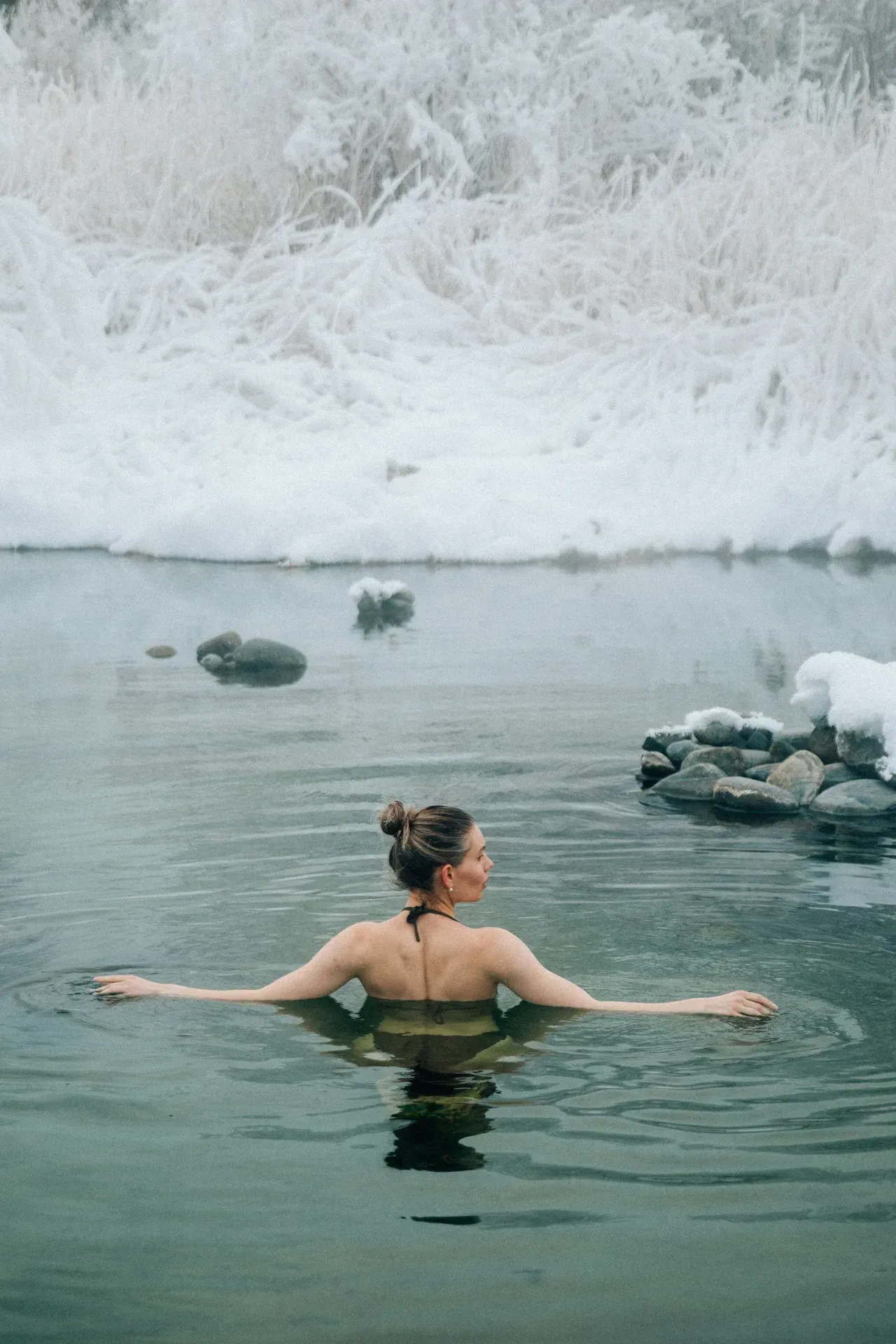 Persona nadando en un lago helado en invierno, donde el frío extremo aumenta el riesgo