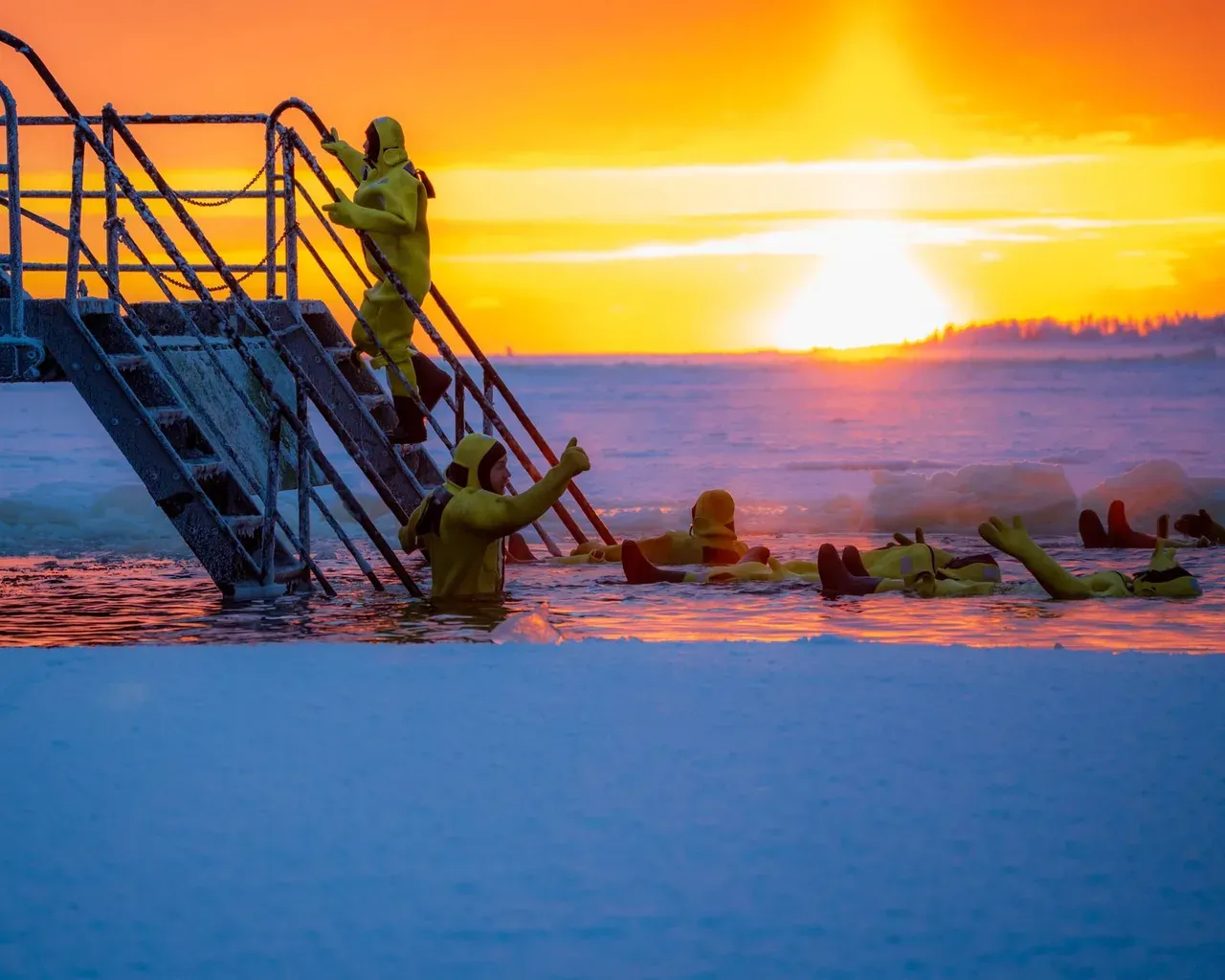 Grupo de deportistas realizando un baño de hielo al amanecer