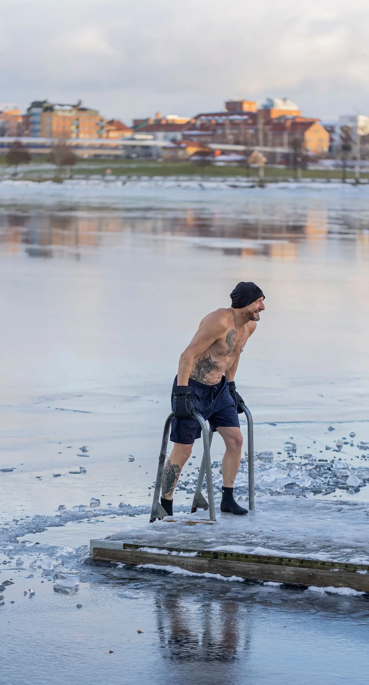 Persona saliendo del agua helada tras una inmersión en frío en invierno