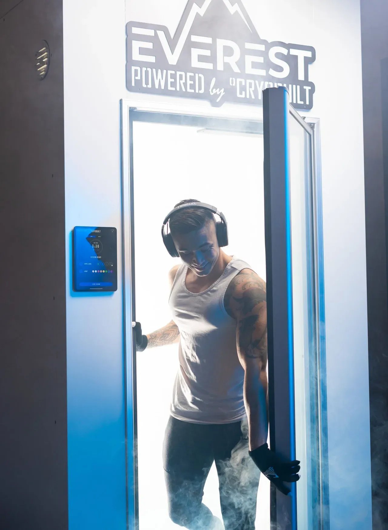 Persona saliendo de una cabina de crioterapia de cuerpo entero entre vapor frío