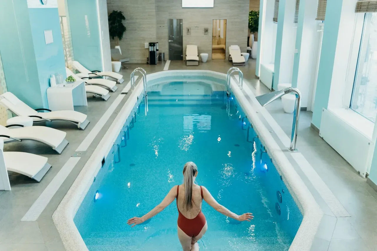 Persona a punto de sumergirse en una piscina de agua fría con equipo de enfriamiento