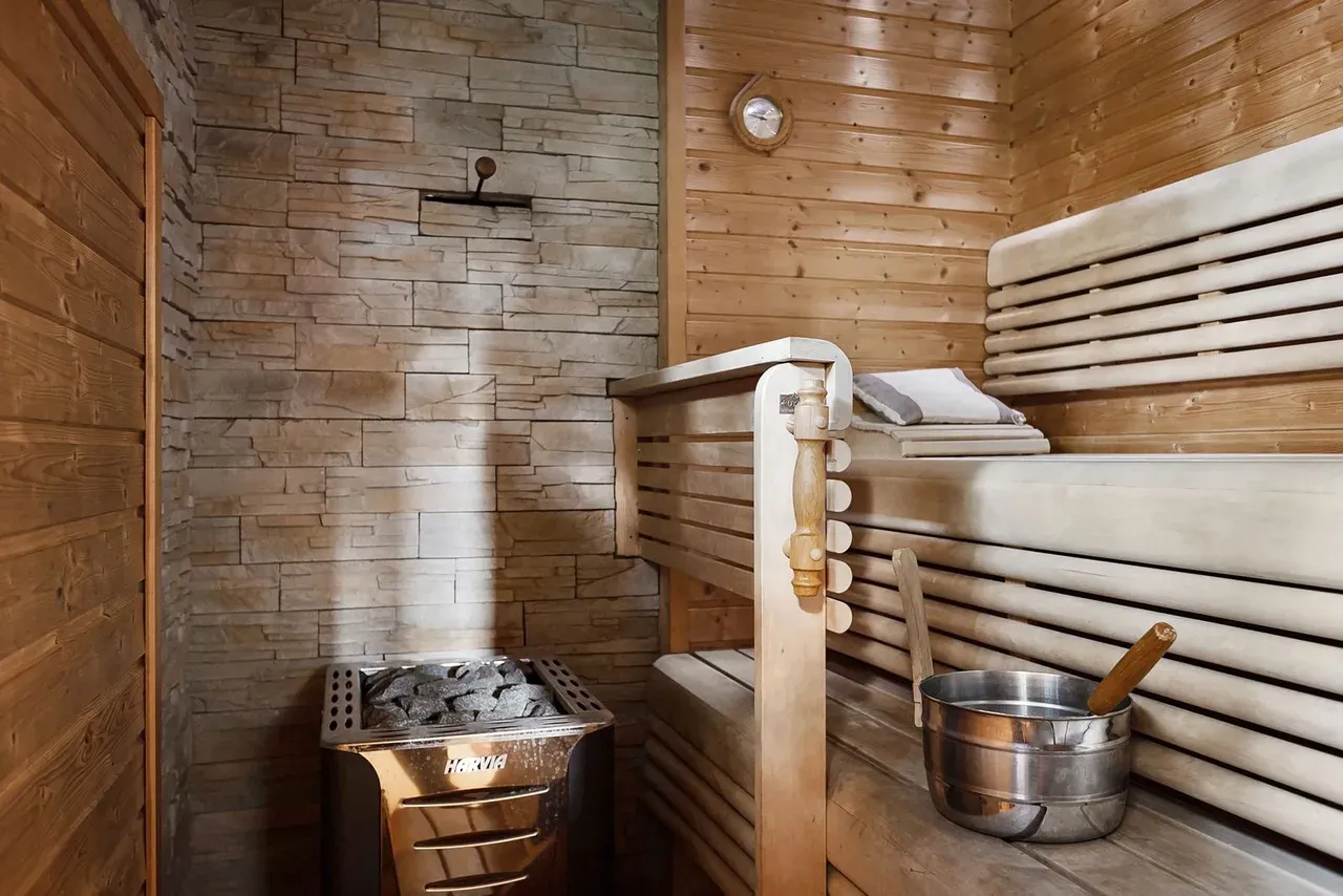 Interior de una cabina de sauna de infrarrojos con bancos de madera
