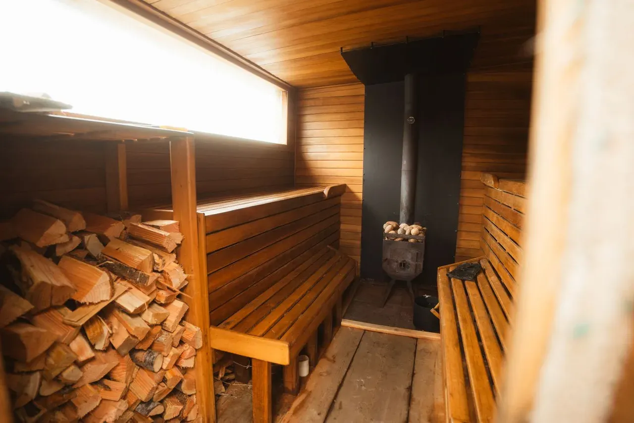 Interior de una sauna finlandesa tradicional de madera con bancos y estufa