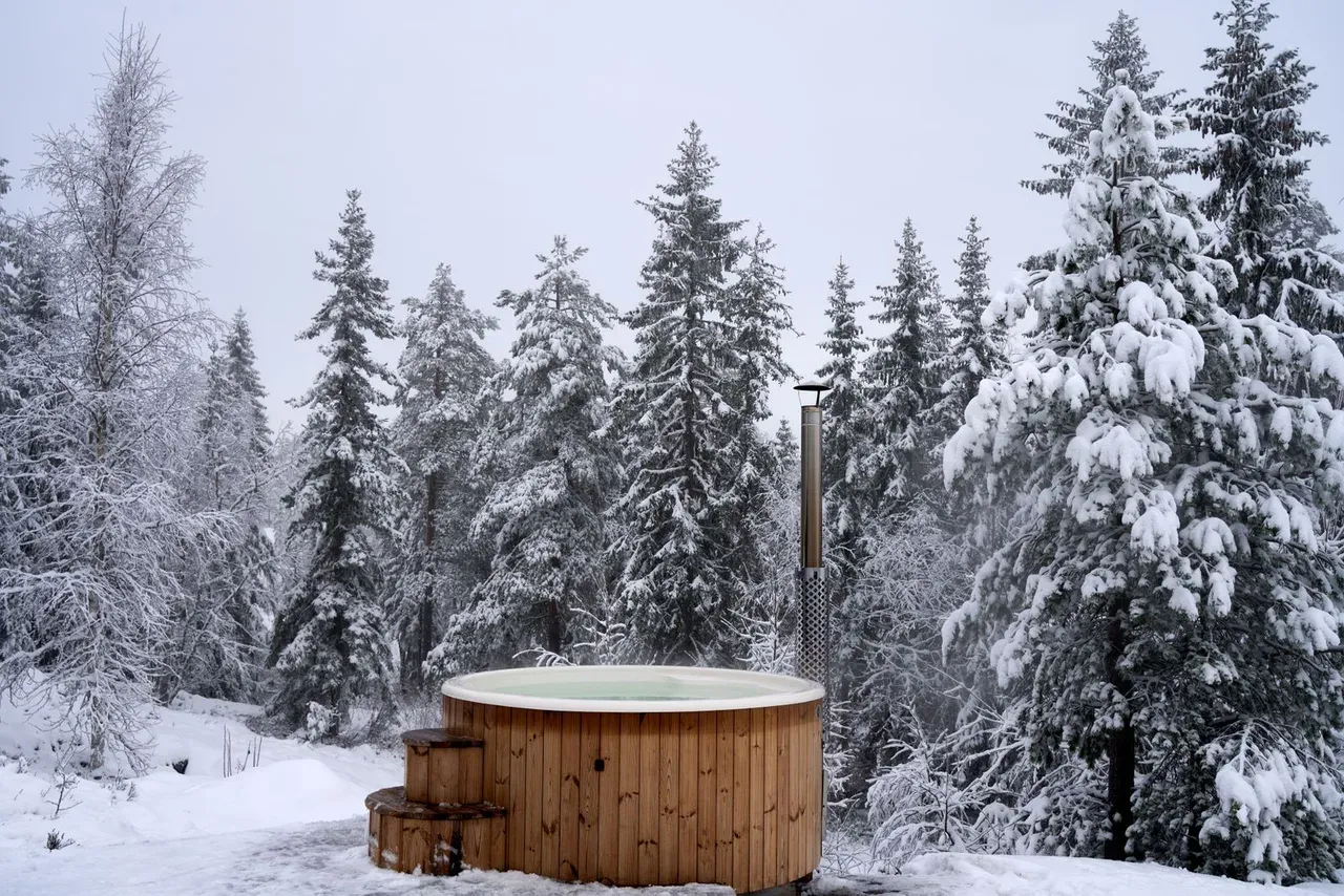 Persona sumergida en agua helada al aire libre, un cold plunge en un lago con hielo